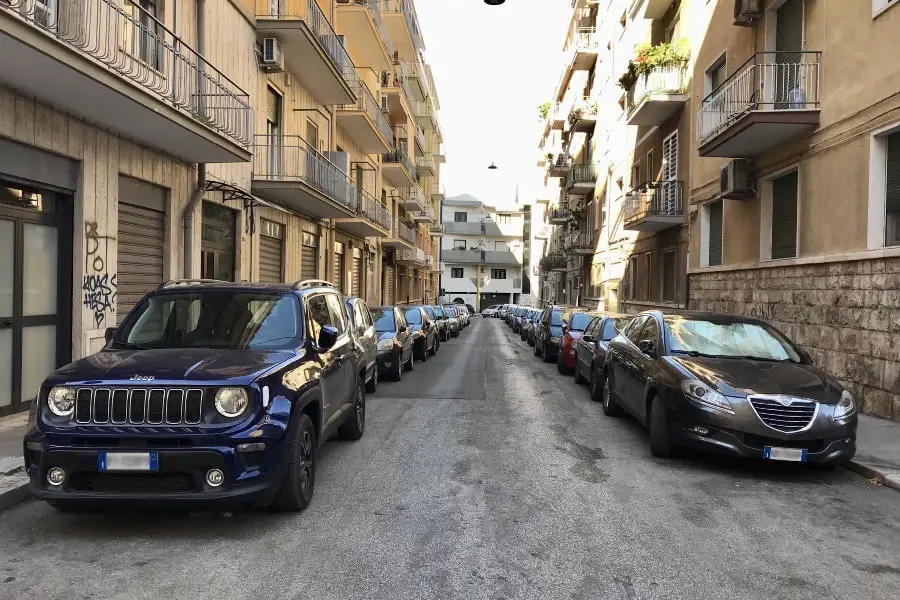 Cars parked in both sides of the road.